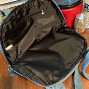 A blue Jean pocket book back pocketbook opens all the way to carry a book in